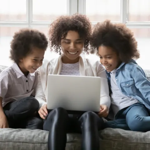 Mom and children sitting in front of a laptop