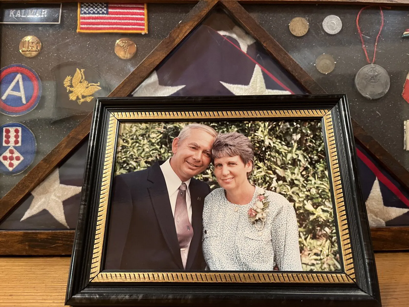 Picture of a man and woman smiling with an american flag in background