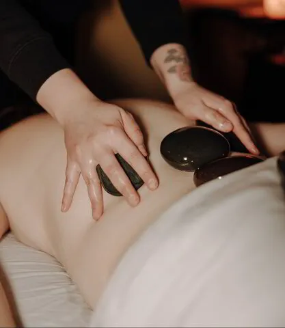Owner performing hot stone massage  technique