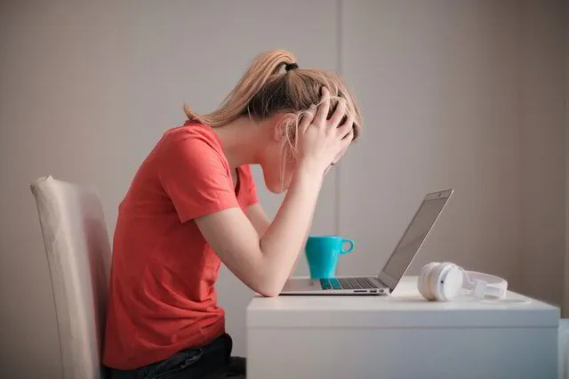 Woman sitting at desk with upper back pain