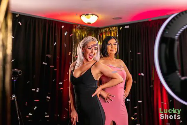 two women standing on a 360 photo booth platform