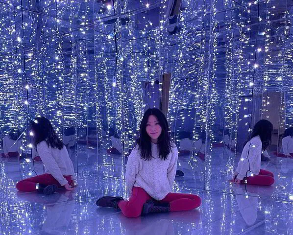 girl sat down posing surrounded by lights and mirrors