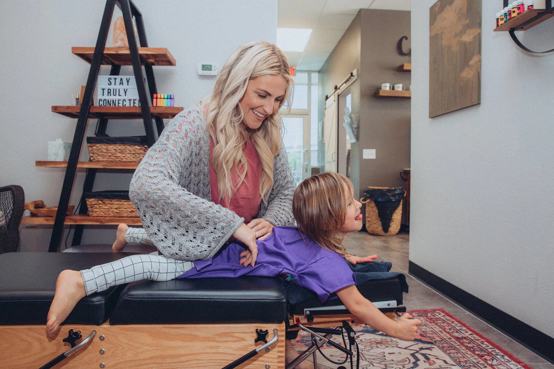 Dr. Morgan gently prepares a young patient for a chiropractic adjustment, showcasing her child-friendly approach at Truly Chiropractic