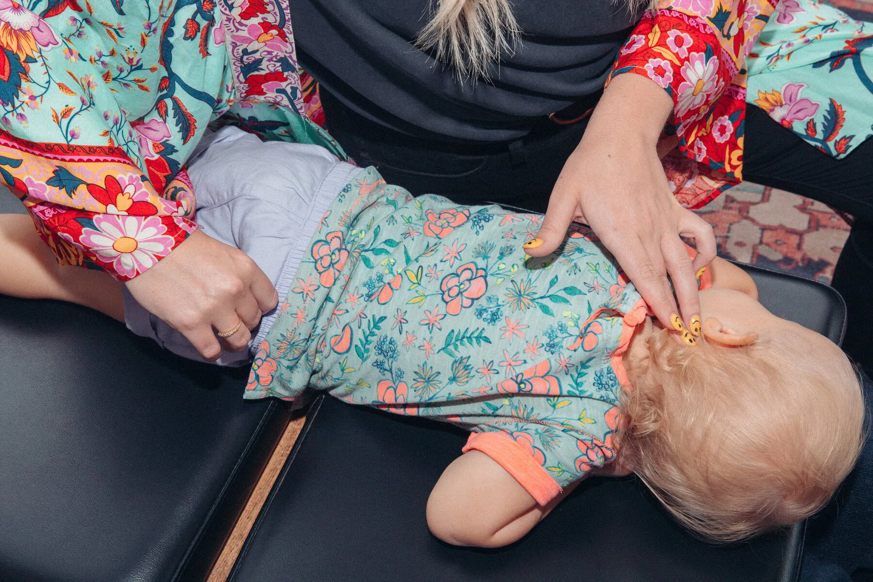 Dr. Morgan gently examines a toddler's head, showcasing her expertise and the trusting atmosphere of Truly Chiropractic