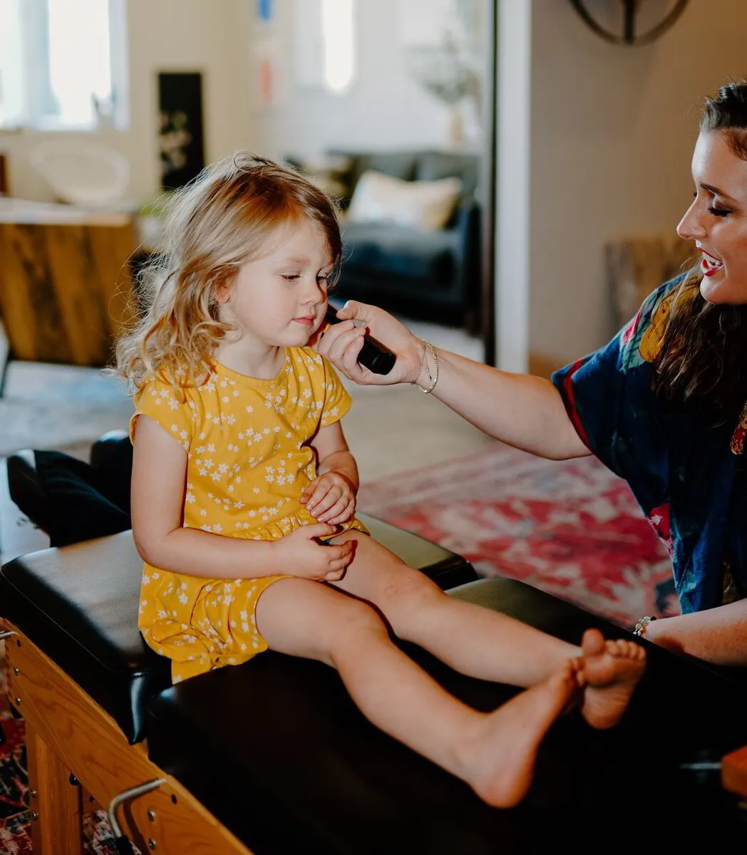  Dr. Morgan engages gently with a young child, using her expertise in pediatric chiropractic