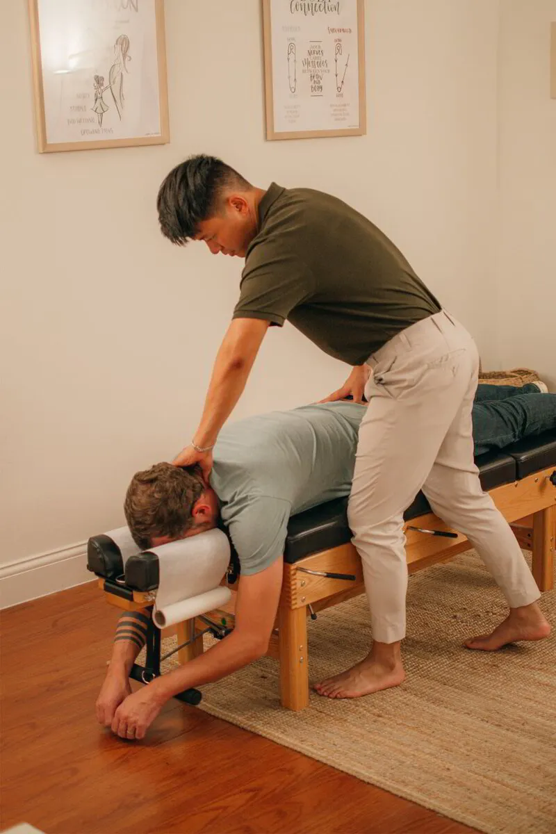 Dr. Binh applies precise pressure to a patient's back, showcasing his commitment to improving well-being through chiropractic care