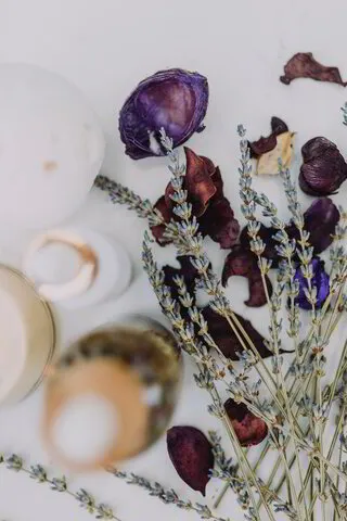 lavender sprigs, purple petals, blurred bottles of oil 