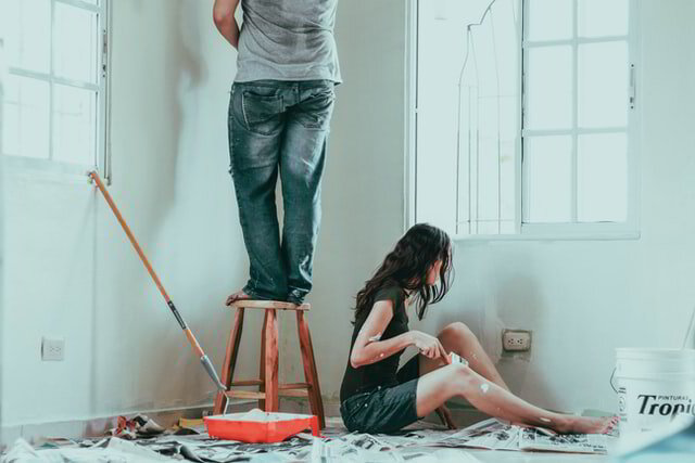 Couple painting a bedroom