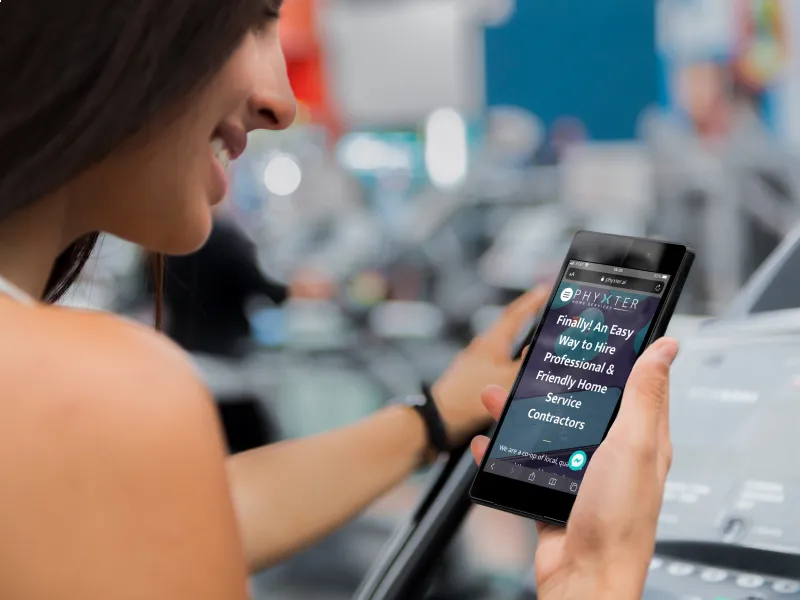 Beautiful woman checking out Phyxter Mobile website at a gym