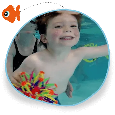 A little boy swims underwater in his swimming lesson and he holds a colourful sensory toy