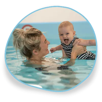 A mum and a baby smile in a swimming pool