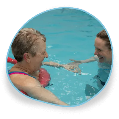 An adult is led by a teacher in a beginners’ swimming lesson