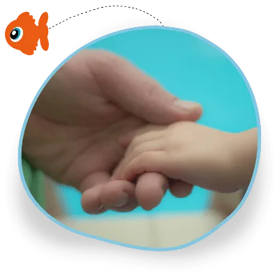 A close-up of an adult holding a child's hand with a swimming pool in the background
