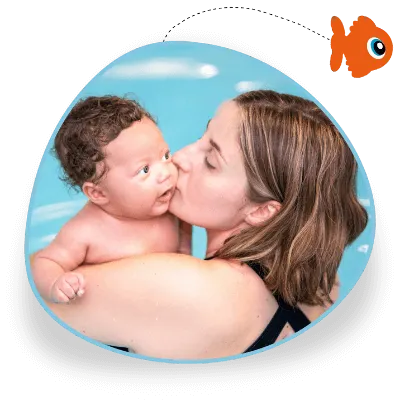 A woman kisses her baby on the cheek as they cuddle in a pool
