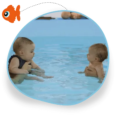 Two adults hold their babies in the swimming pool and the babies are looking at each other