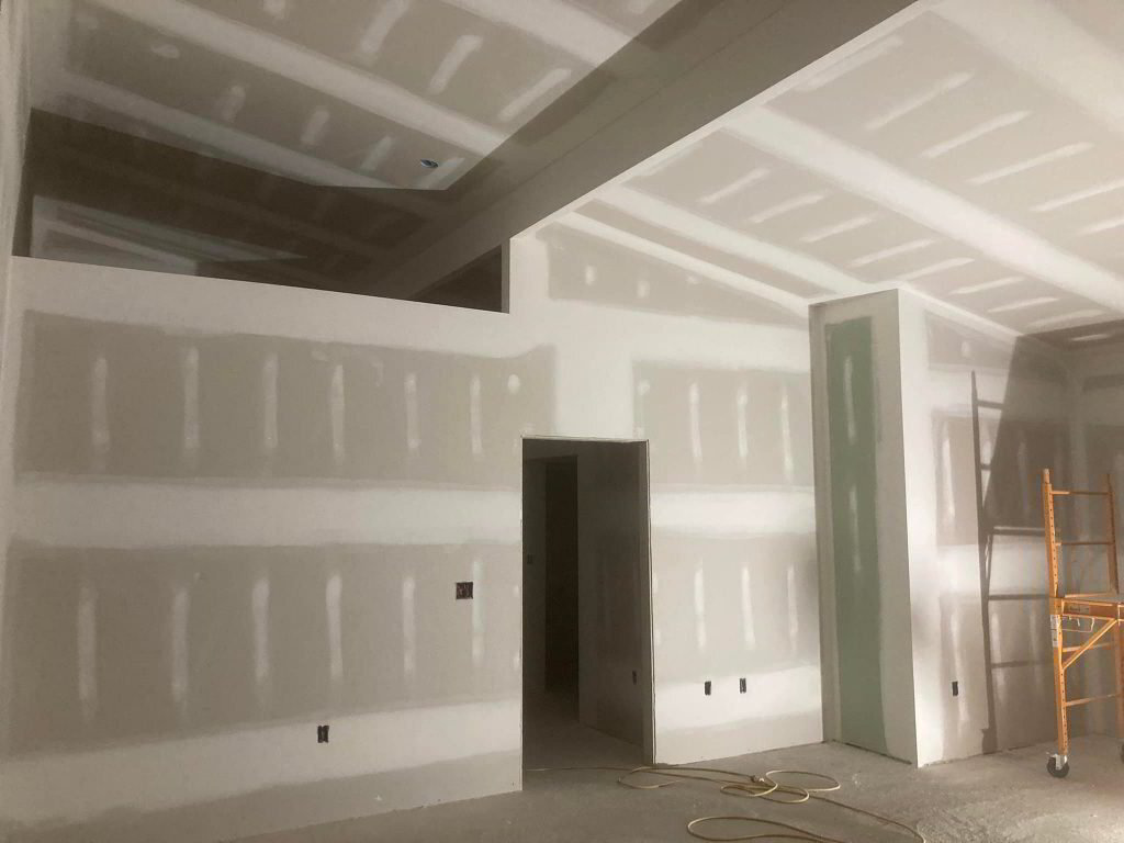 Alta technician installing and repairing drywall on an interior wall in Addison IL