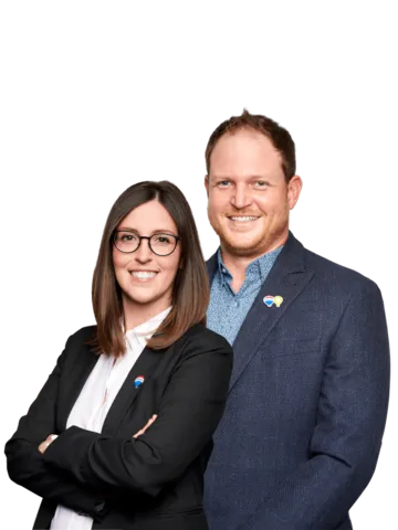 In this captivating team photo, the award-winning husband and wife real estate duo, Patrick and Kayla Kozierowski, exude confidence and success. The pair stands shoulder to shoulder, dressed in sharp professional attire that reflects their commitment to excellence in the real estate industry.