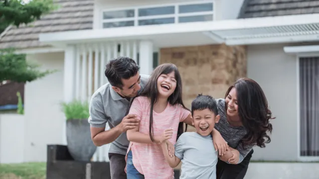Picture-perfect happiness: Family joyfully poses with their new house.