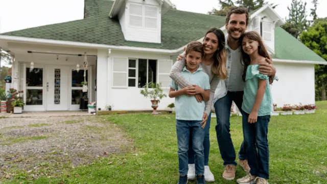 Home is where the smiles are: Happy family in front of their property.