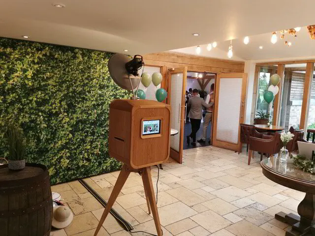 Photo booth at Mythe Barn Wedding Venue with foliage wall backdrop
