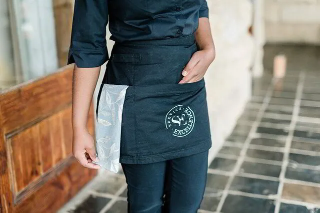 Service Excellence waitress with her hand in the apron
