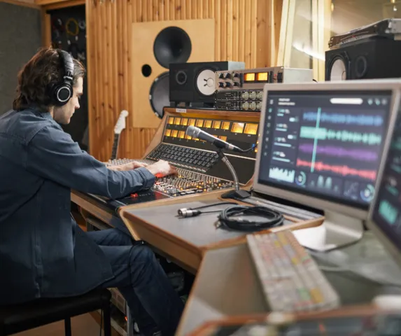 A man editing Christian Music at a mixing board.