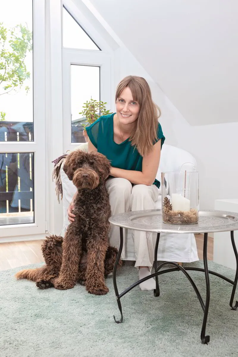 hundterapi terapi samtalsterapi kvinna hund labradoodle brun fåtölj vit grön natur medvetenhet gemenskap trygghet 