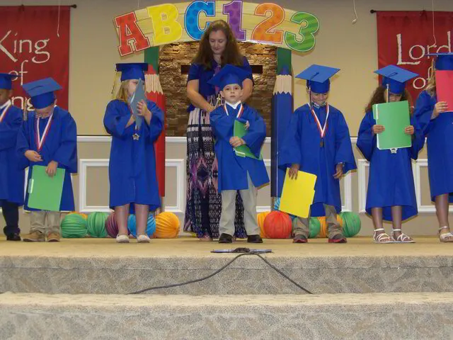 teacher standing with young students graduating