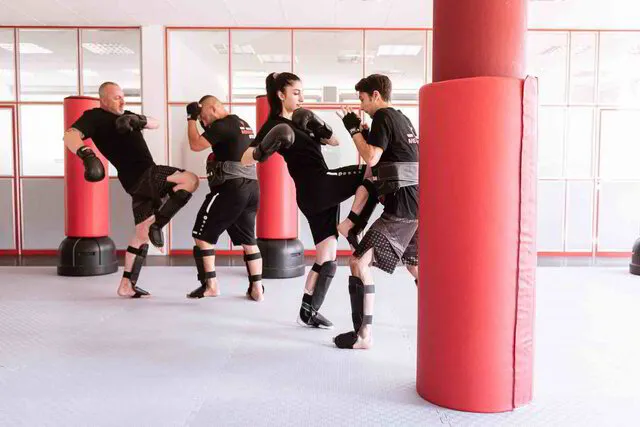 Jugendliche üben zusammen Selbstverteidigungstechniken in der Warrior Karate 10-15 Jahre Einheit