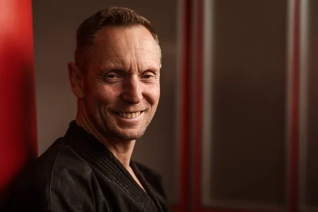 Thomas Geiger, Inhaber der Kampfkunstschule Geiger, lächelt freundlich und vertrauenswürdig in die Kamera
