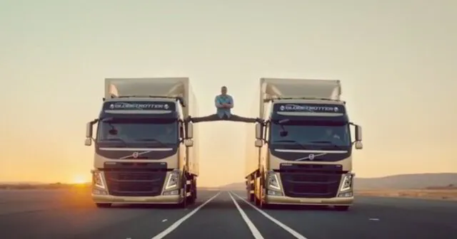 Un entrepreneur fait le grand écart facial entre deux camions.