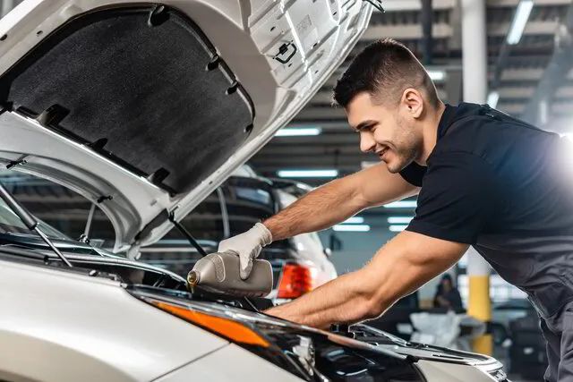 male employee changing the oil on a vehicle