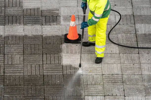 Man pressure washing a commercial patio