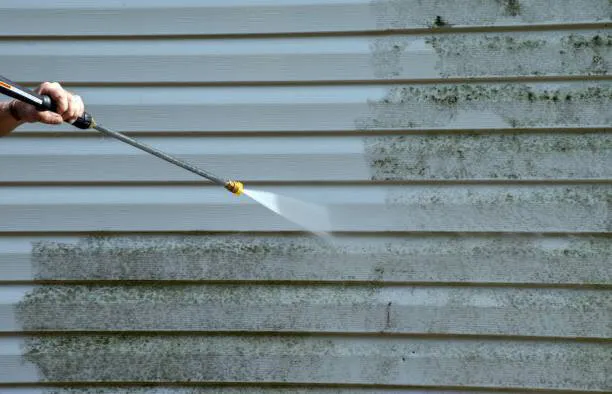 Pressure washing the siding on a house