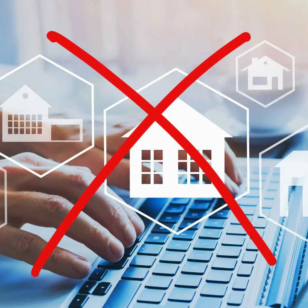 Ablehnung unzuverlässiger Online-Bewertungen für Immobilien, gezeigt durch eine Hand, die auf einem Laptop mit durchgestrichenen Haus-Symbolen arbeitet.